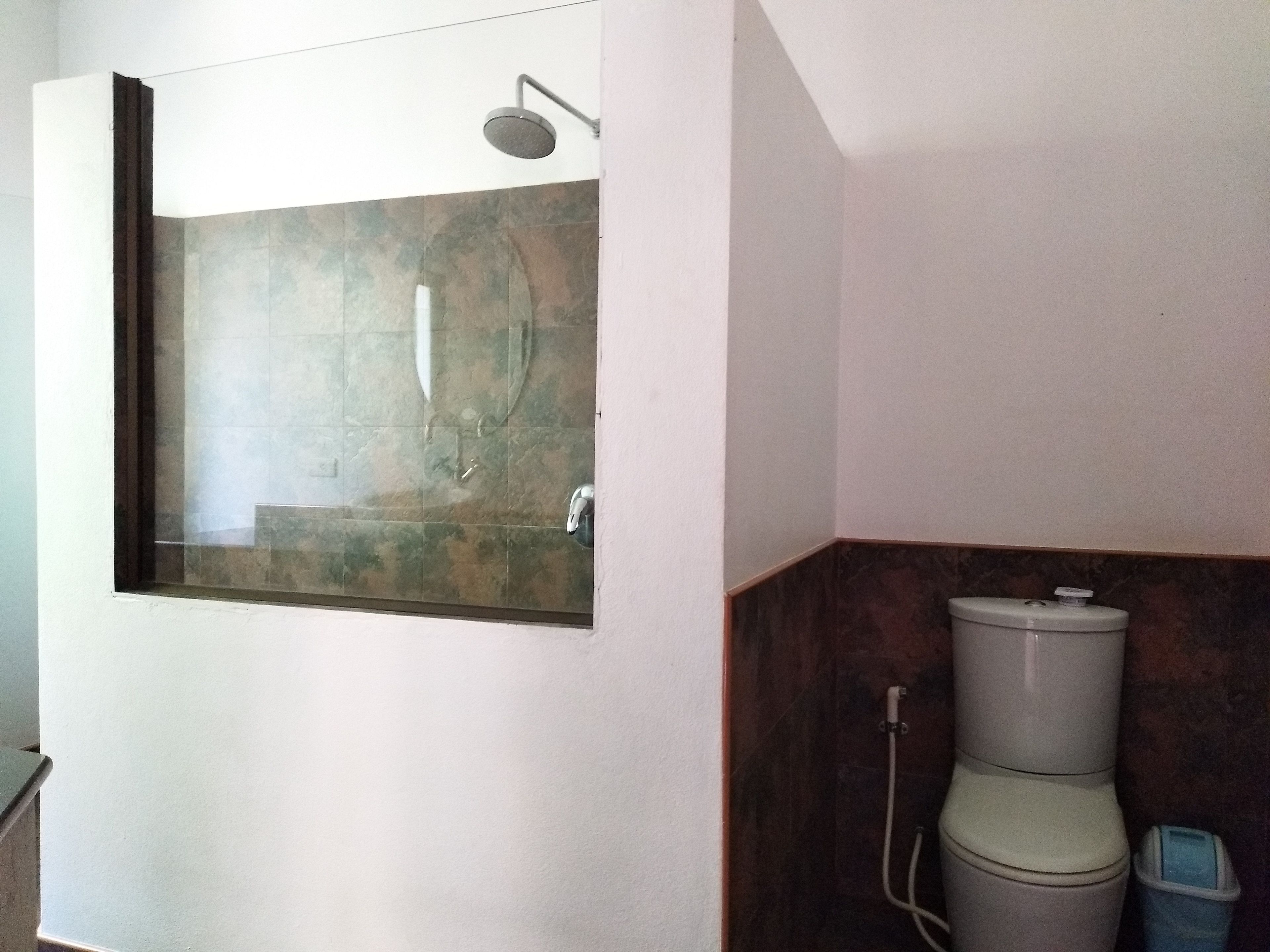 Ein Badezimmer mit Dusche, Toilette und Bidet.