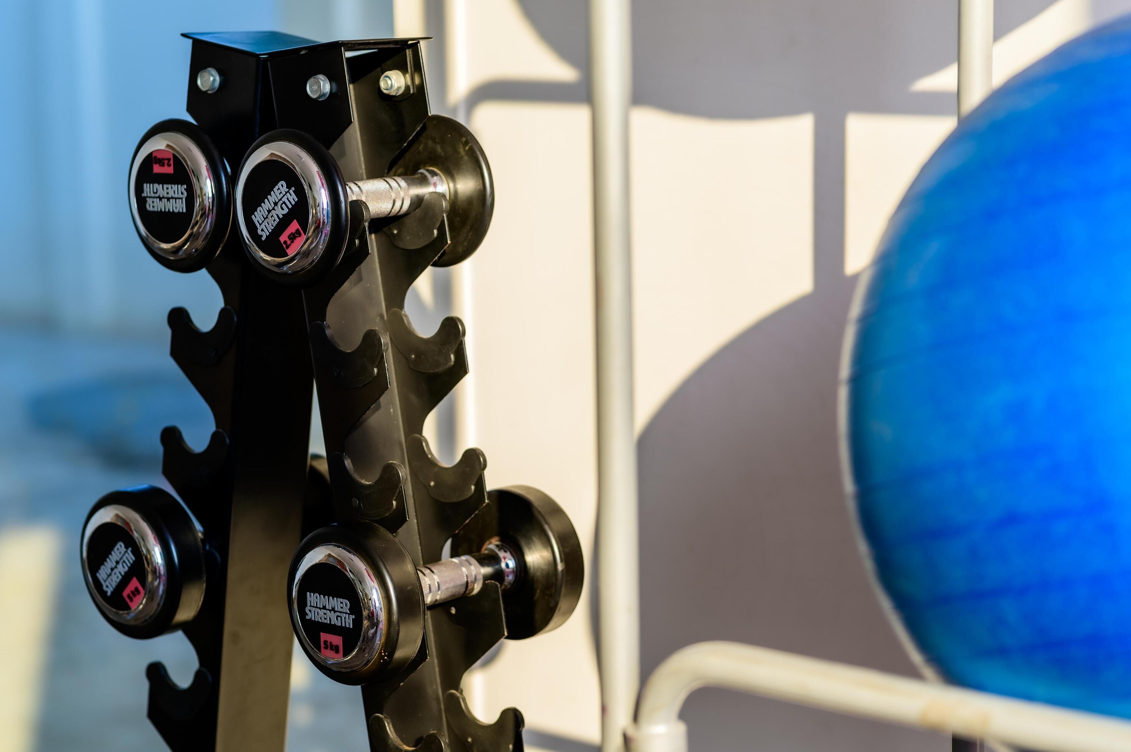 A close-up of a mechanical device with multiple adjustment knobs labeled "Hammer Strength."