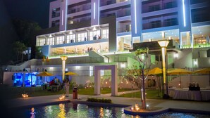 Un hotel de varios pisos con zona de estar al aire libre y área de piscina.