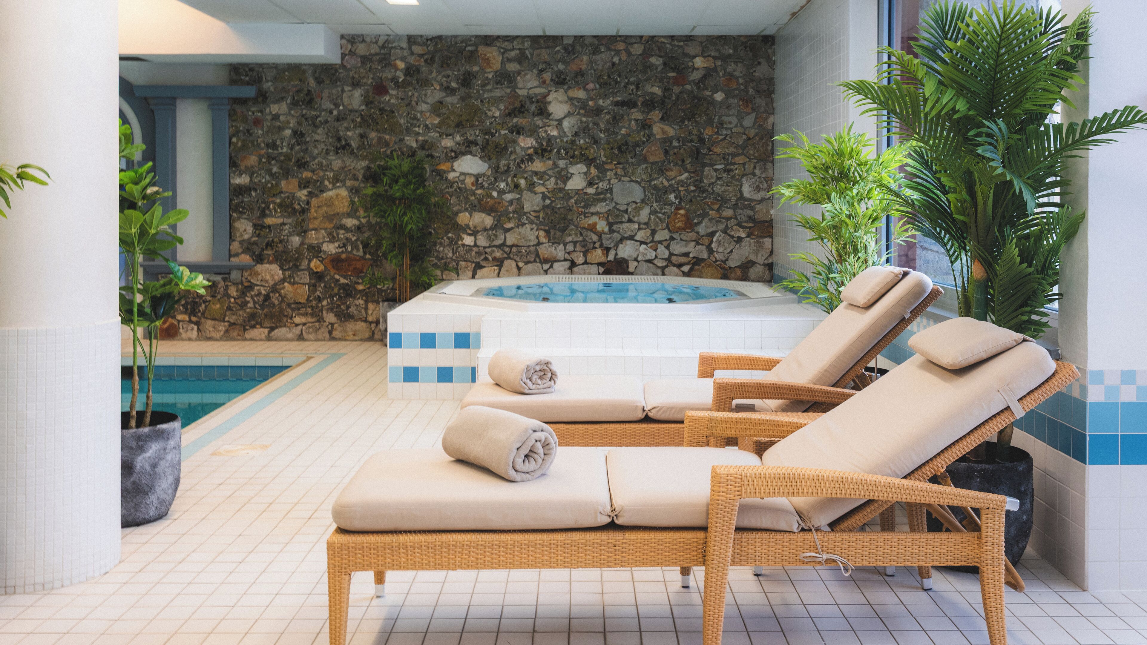 Una piscina cubierta, tumbonas