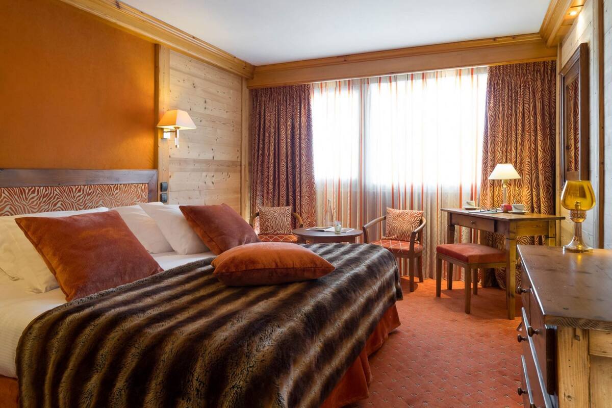 Una habitación de hotel con cama, escritorio, silla y mesa.