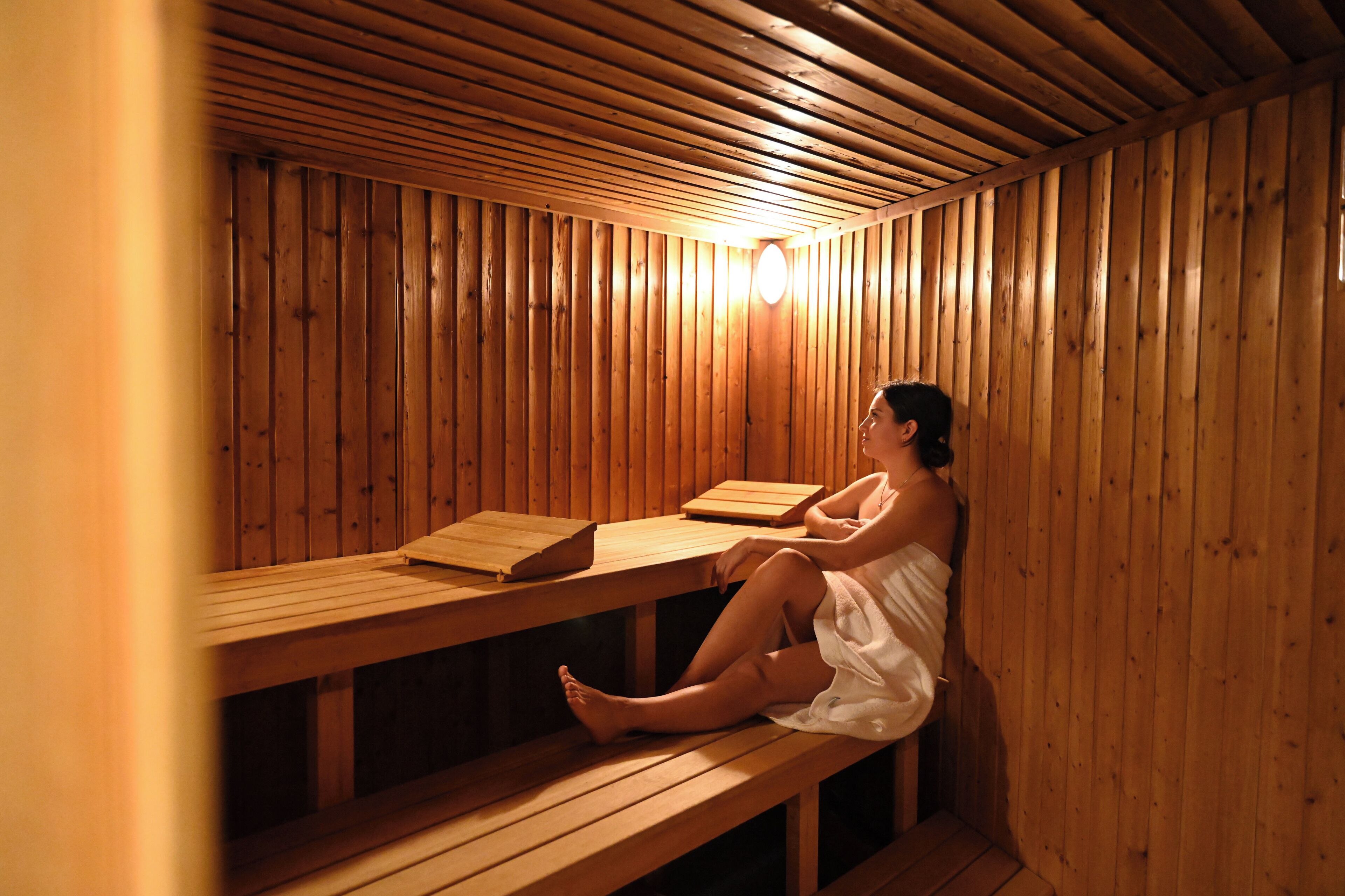 A wooden sauna with benches and a bench with a towel.