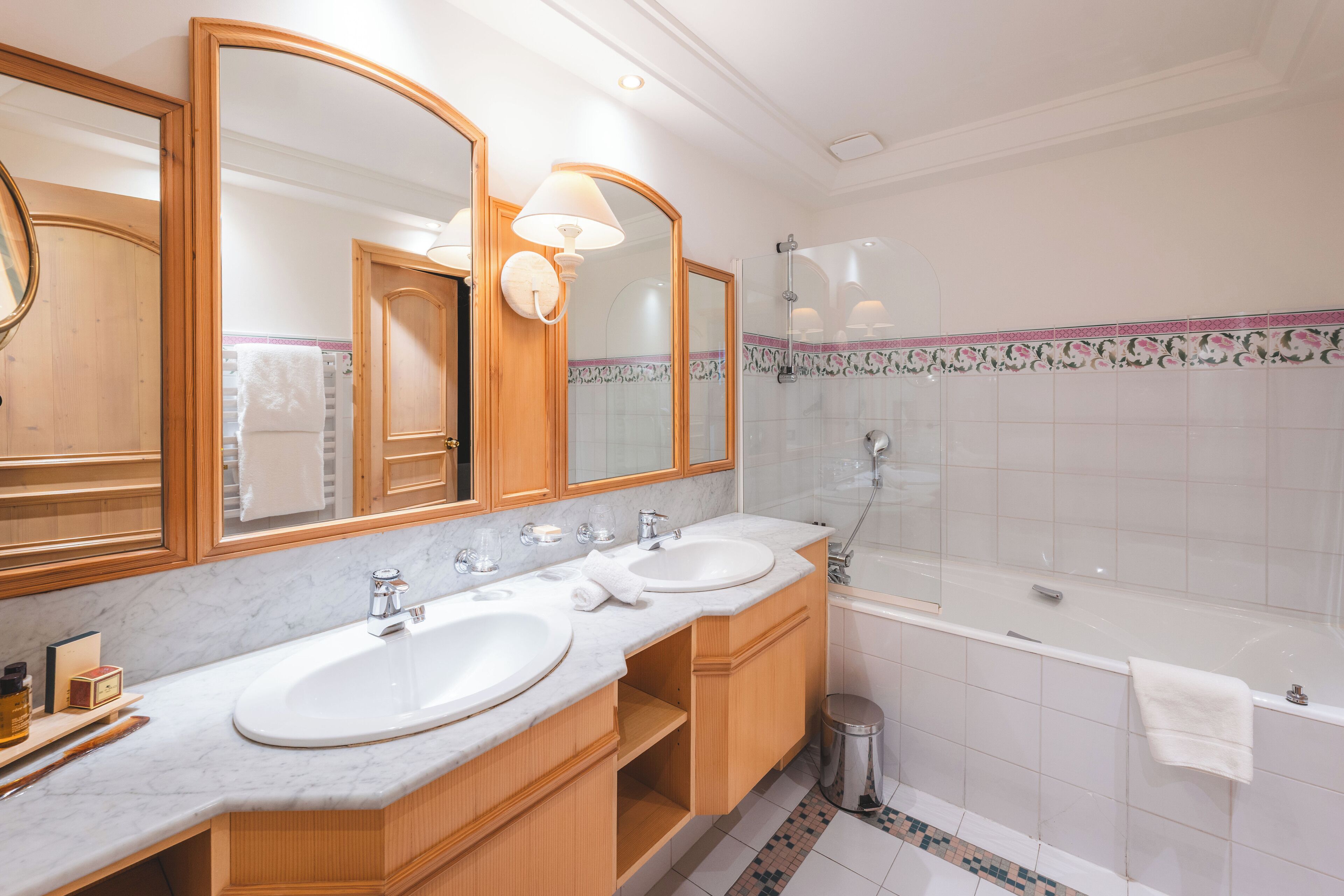 Une salle de bain avec deux lavabos, un miroir et une baignoire.