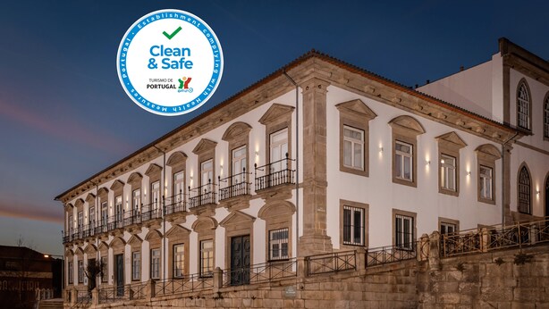 Ein historisches Gebäude mit einer Stein-Fassade, zahlreichen Fenstern und einem Balkon.