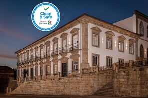 Un bâtiment historique doté d’une façade en pierre, de nombreuses fenêtres et d’un balcon.