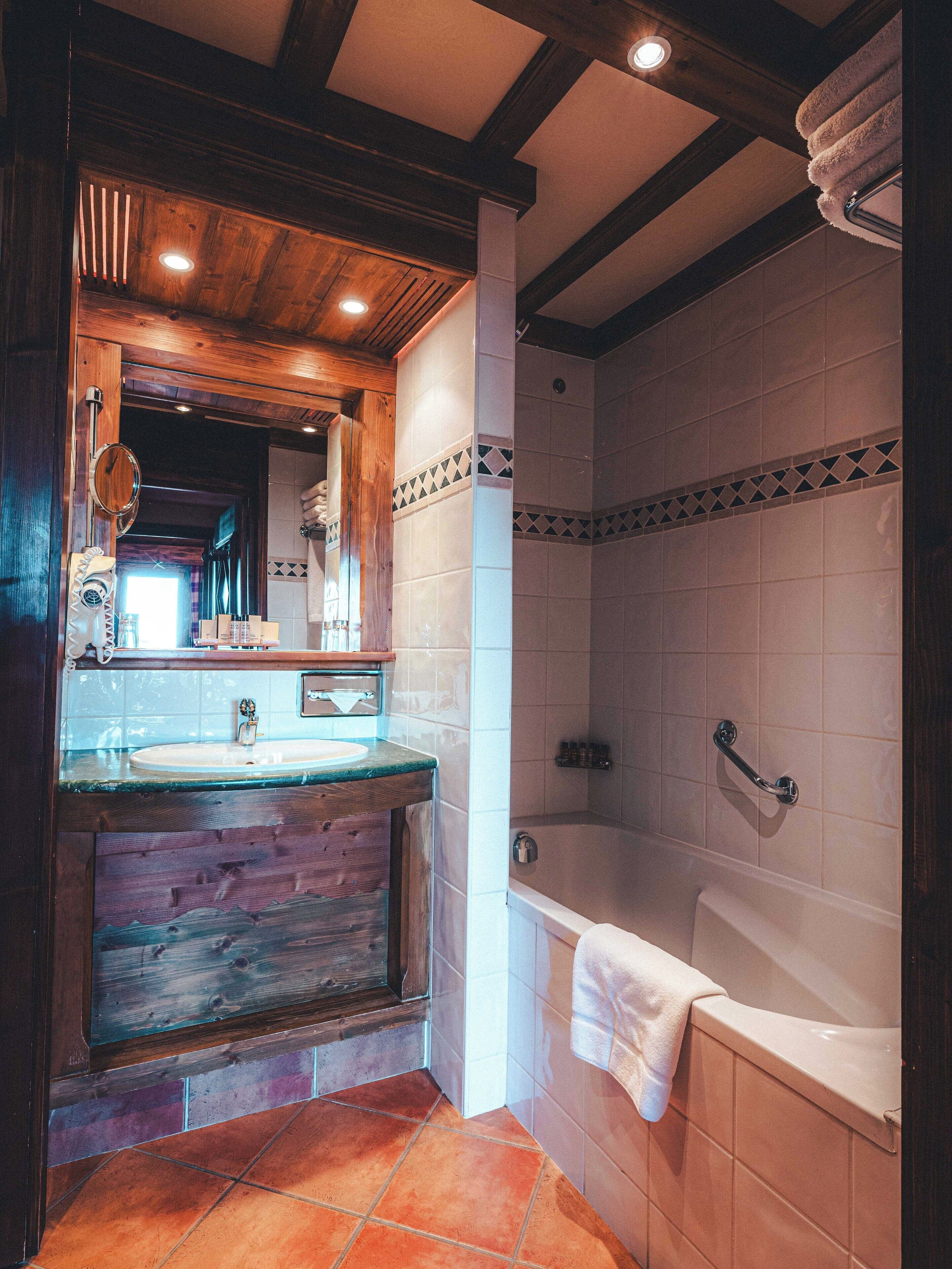 Un baño con tocador de madera, bañera y zona de ducha.