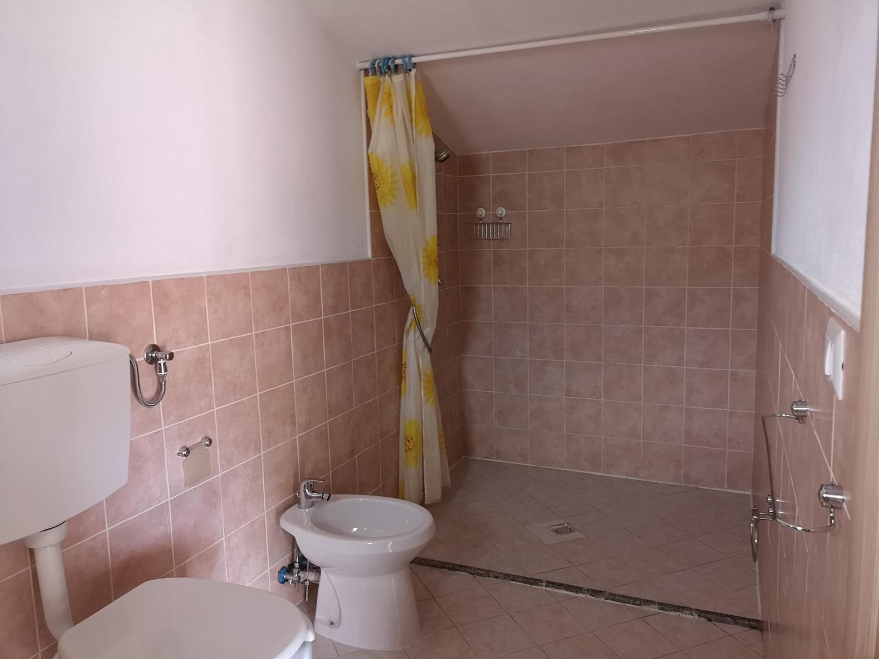 Kylpyhuone, jossa on wc, bidee ja suihkutila.