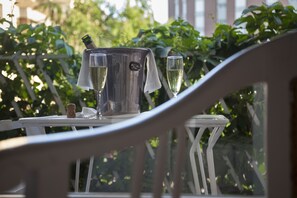 A table with a champagne bucket and glasses, set outdoors with greenery in the background. - Hotel & Restaurant Vostra Llar (Palamós)