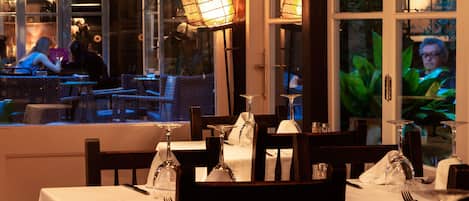Un restaurante con mesas dispuestas para comer, con vistas a través de la ventana.