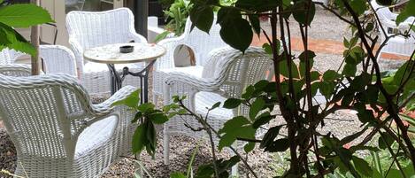 Een terras met rieten meubilair en een decoratieve lantaarn.