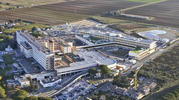 An airport terminal with multiple buildings, parking areas, and a runway.