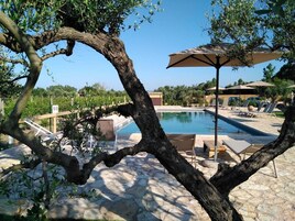 Una piscina al aire libre de temporada, sombrillas