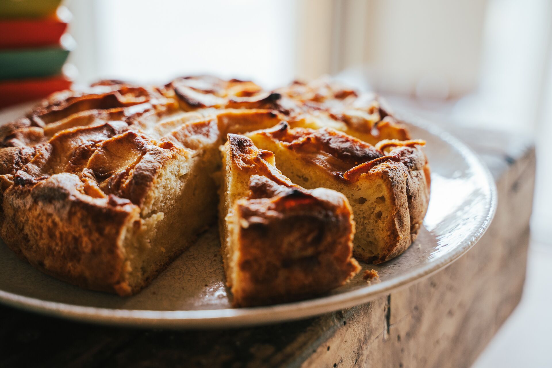A round cake with a golden-brown crust on a white plate.
