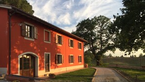 A red building with multiple windows and a curved driveway.