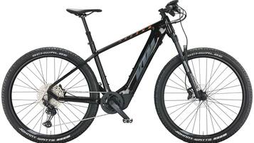 A mountain bike with a black frame, front suspension fork, and disc brakes.