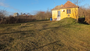Keltainen talo, jossa on punainen katto, satelliittiantenni ja pieni kuisti.