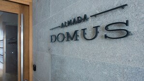 A sign with the words "ALMADA DOMUS" on a stone wall. - Almada Domus (Porto)