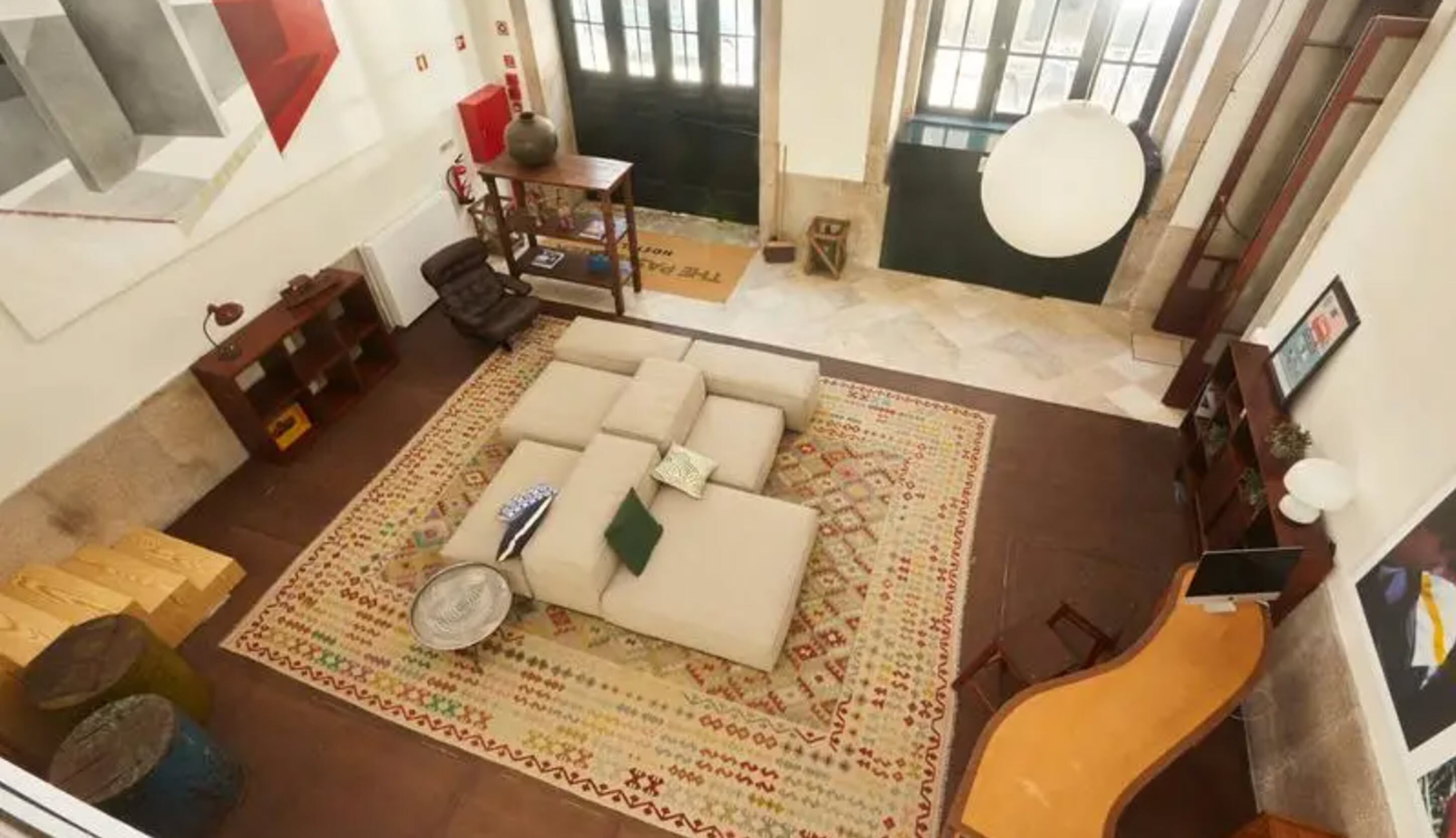 Un salon spacieux avec un grand canapé, un tapis à motifs et une guitare.