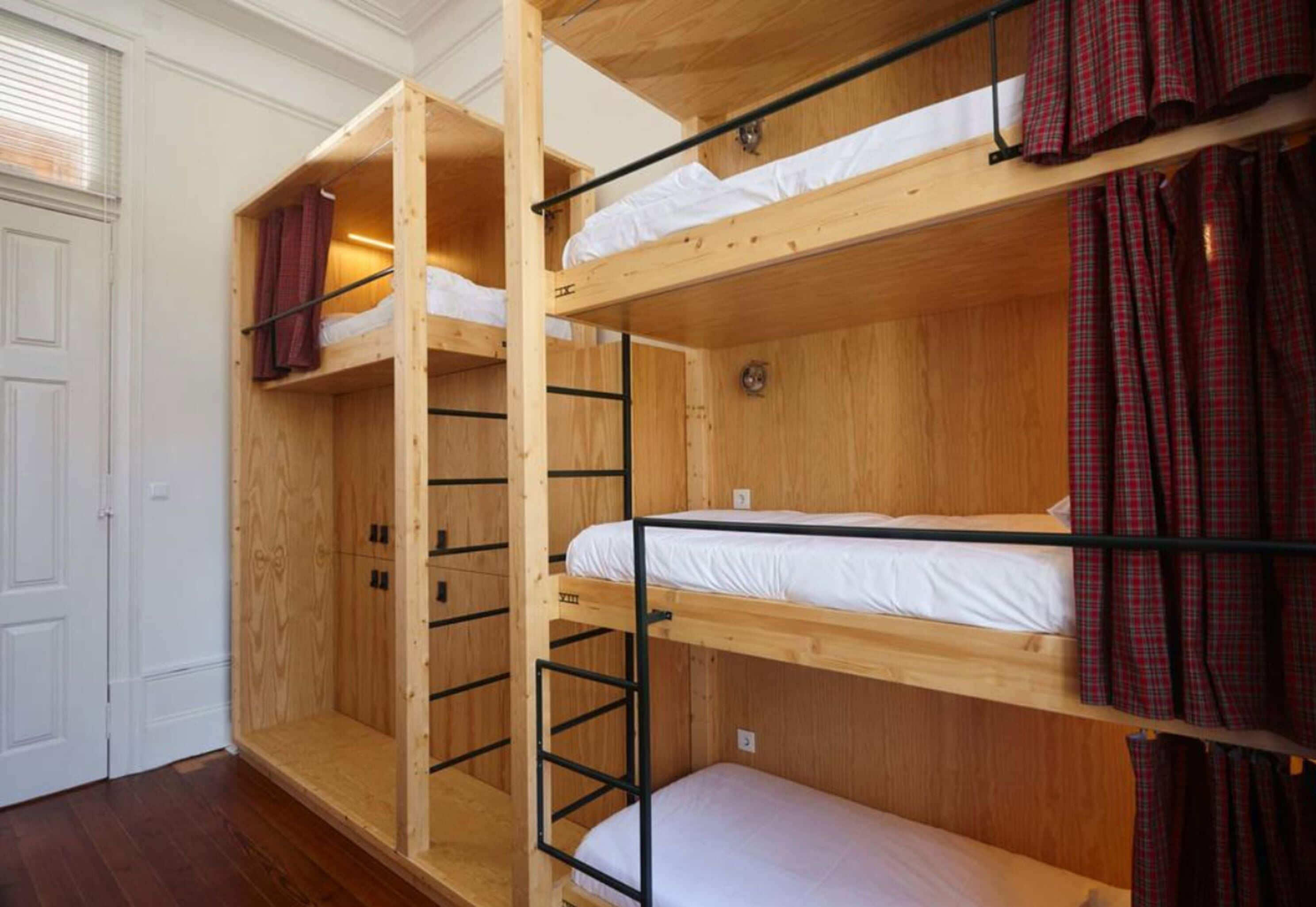 A bunk bed room with wooden walls and a white door.