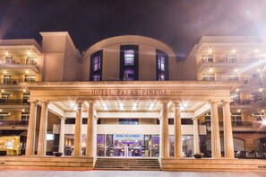 A grand hotel entrance with a large archway, columns, and a sign reading "HOTEL PALAS PINEDA". - Hotel Palas Pineda (Vila-Seca)