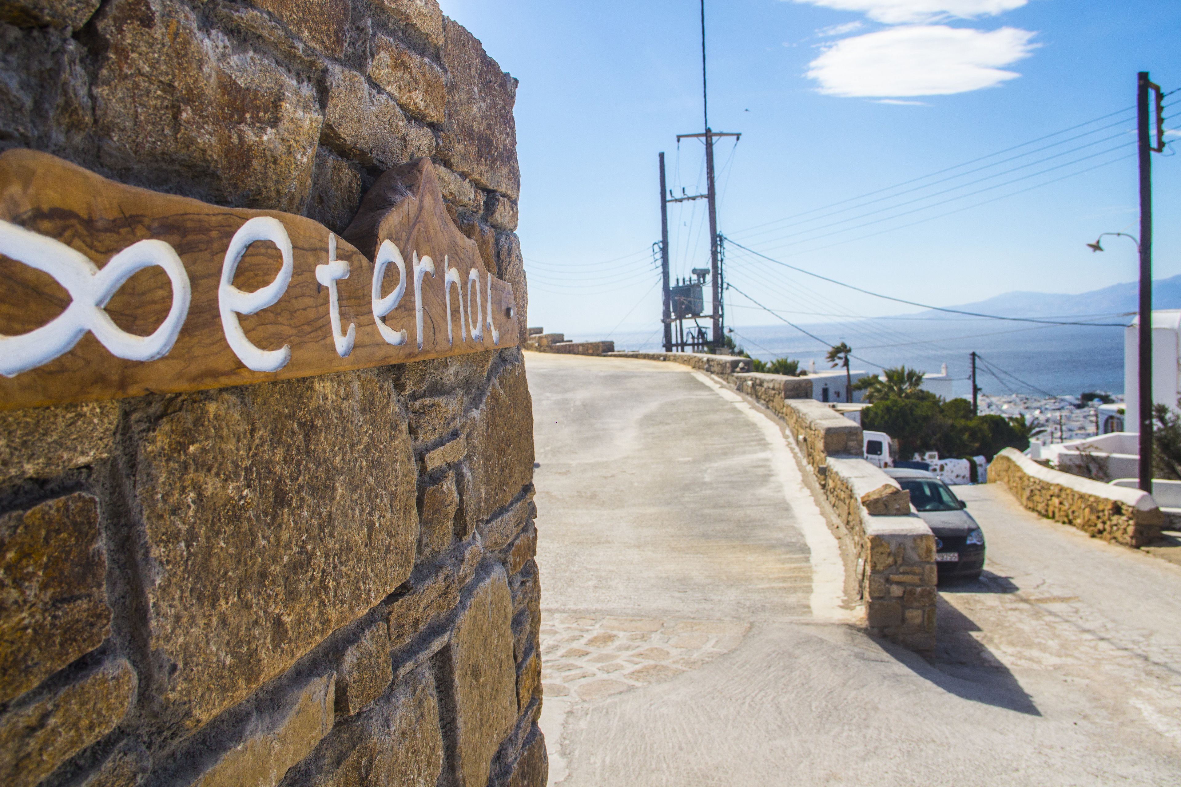 A stone wall with a wooden sign reading "Peternas."