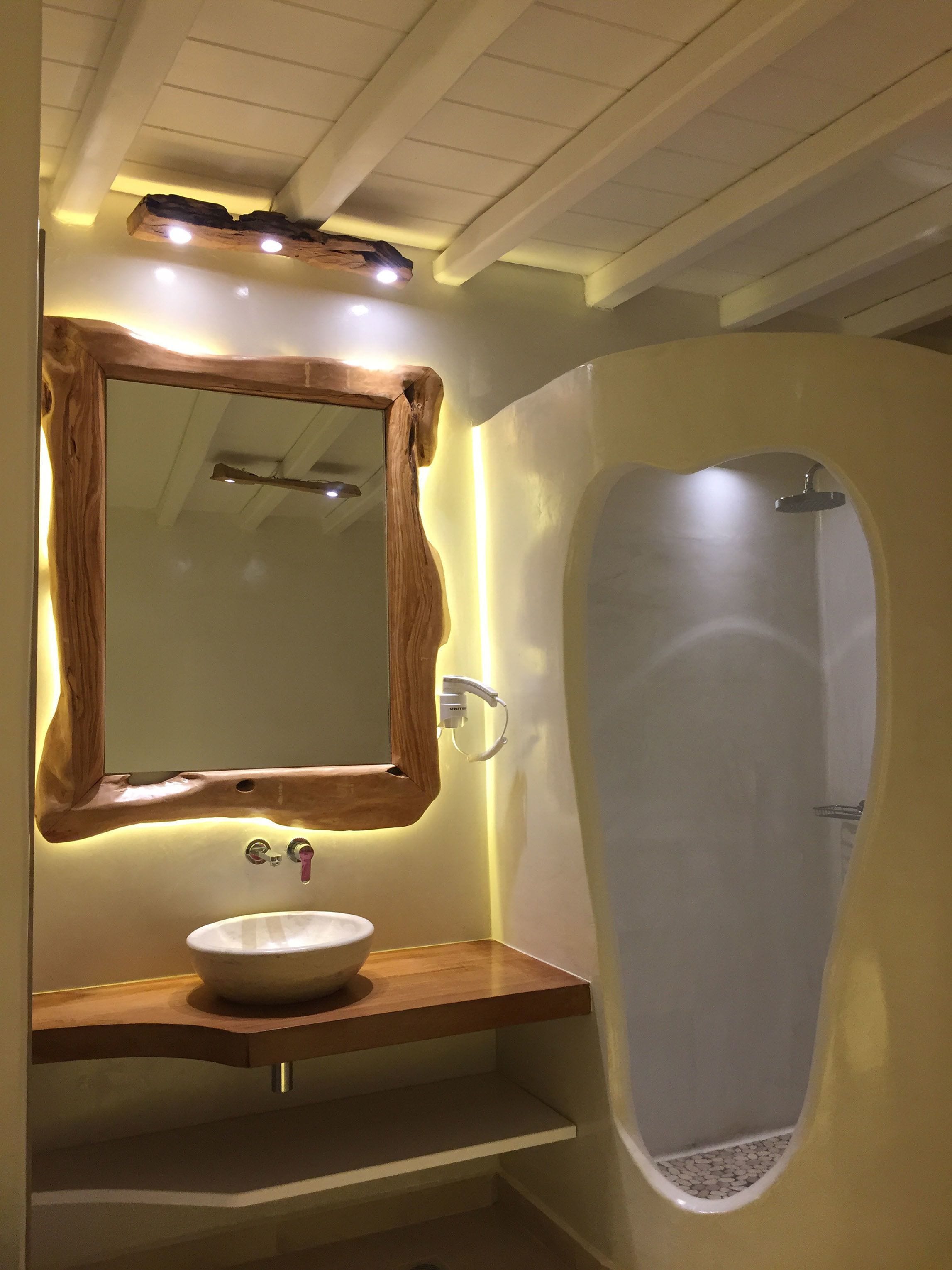 Un baño con tocador de madera, un espejo grande y una cabina de ducha moderna.