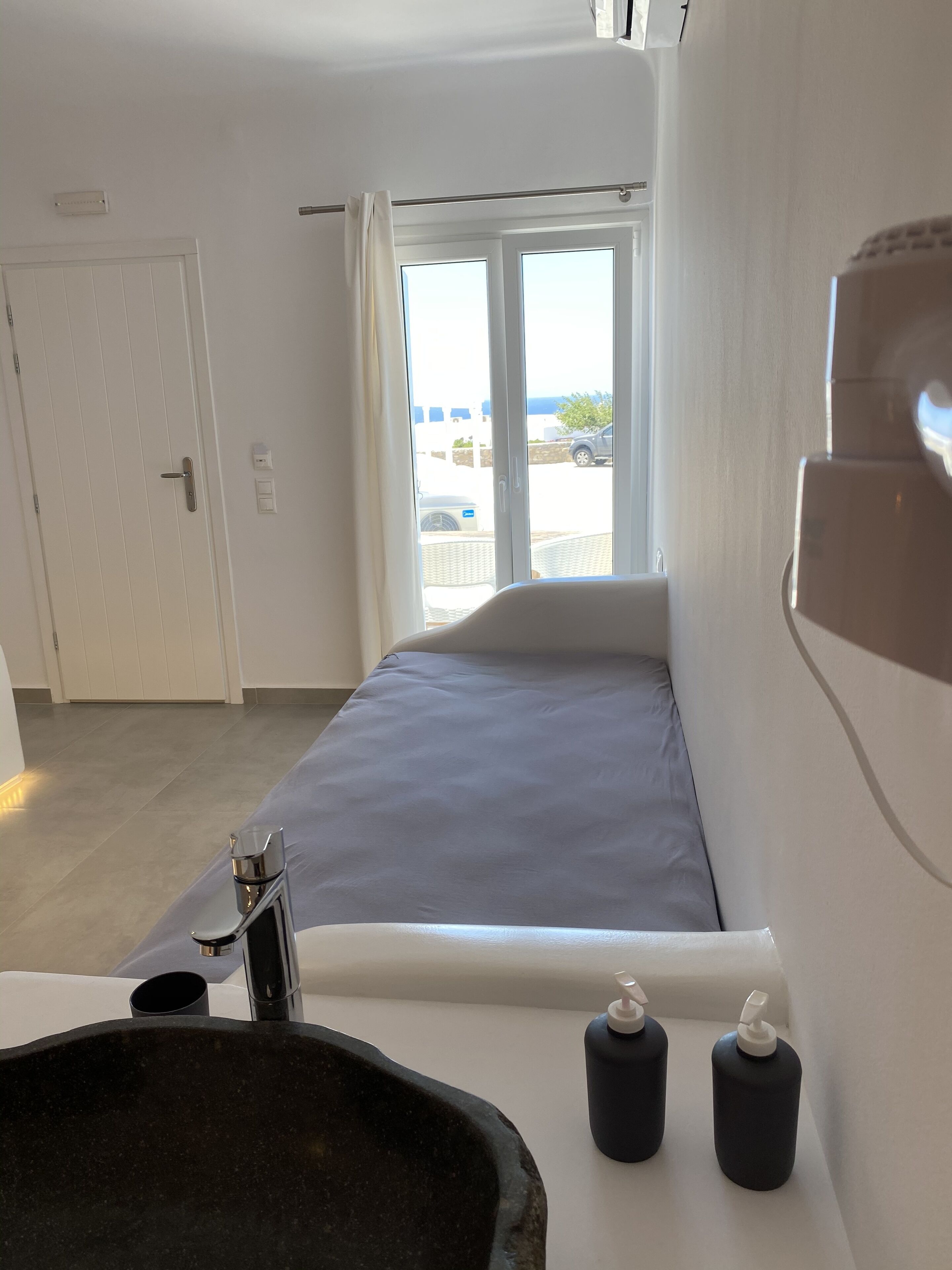 Ein Hotelzimmer mit Bett, Waschbecken und einem Fenster mit Vorhängen.