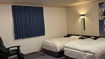 A hotel room with two beds, a desk, a chair, a ceiling light, and a window with curtains.