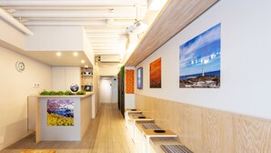 A modern hotel lobby with a reception desk, seating area, and artwork on the walls.