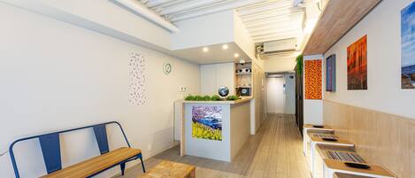 A modern reception area with a bench, a reception desk, and a corridor leading to other rooms.