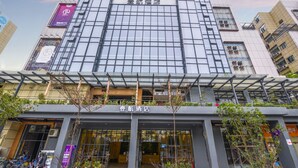 A modern building with a sign reading "FLIGHT-ONE HOTEL" and another sign in a different language. - One Flight Apartment Bao'an Branch (Shenzhen)