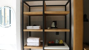 A modern bathroom with a wooden shelf unit containing towels and toiletries. - One Flight Apartment Bao'an Branch (Shenzhen)