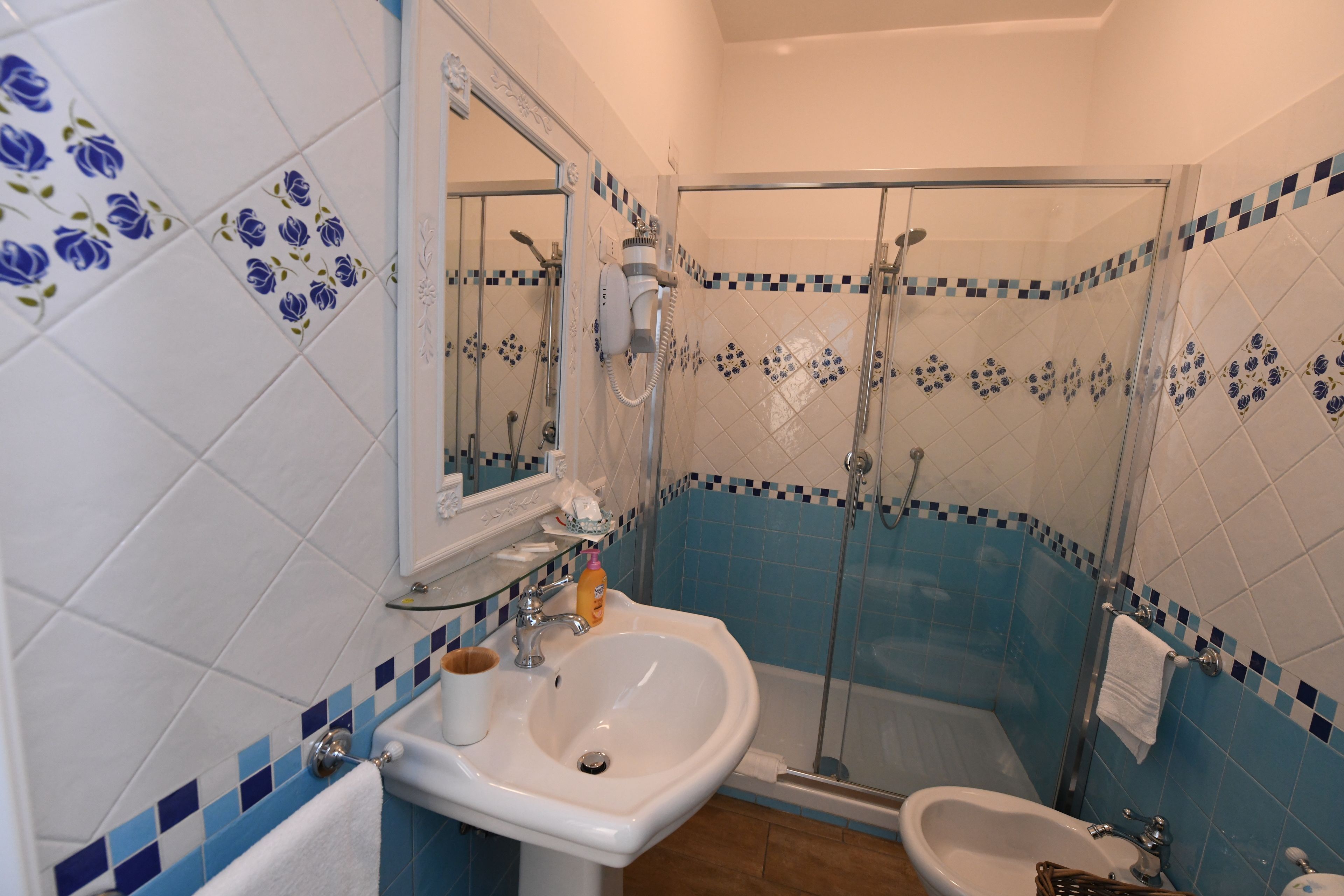 A bathroom with a sink, bidet, and shower.