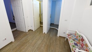 A hallway with white walls and wooden flooring, leading to multiple rooms. - Buonanotte Roma 2 (Rome)