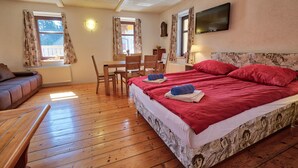 A bedroom with a large bed, wooden floor, a desk, and a chair. - Jacob´s Resort House Podkoren (Kranjska Gora)