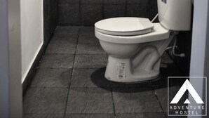 Une petite salle de bain comprenant une douche, des toilettes et un lavabo.