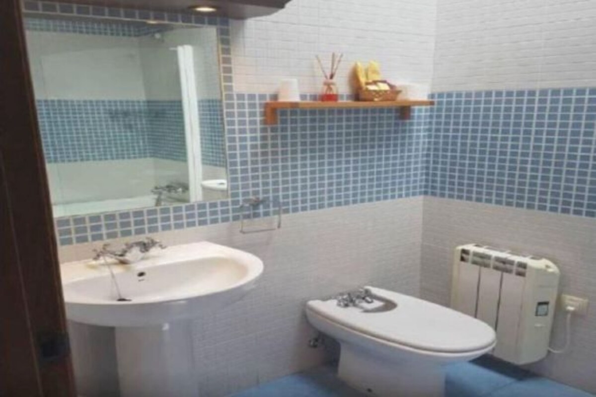 Un baño con lavamanos, inodoro y espejo.