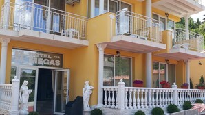 A hotel with multiple balconies, a central entrance, and outdoor seating. - Megas Palace Bankya (Sofia)