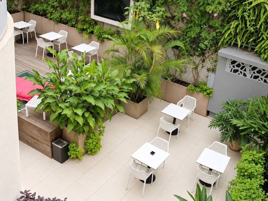 Un jardín en la azotea con mobiliario de exterior y diversas plantas.