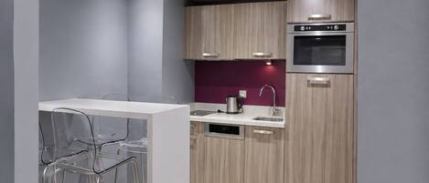 A modern kitchen with wooden cabinets, a stainless steel oven, and a white countertop.