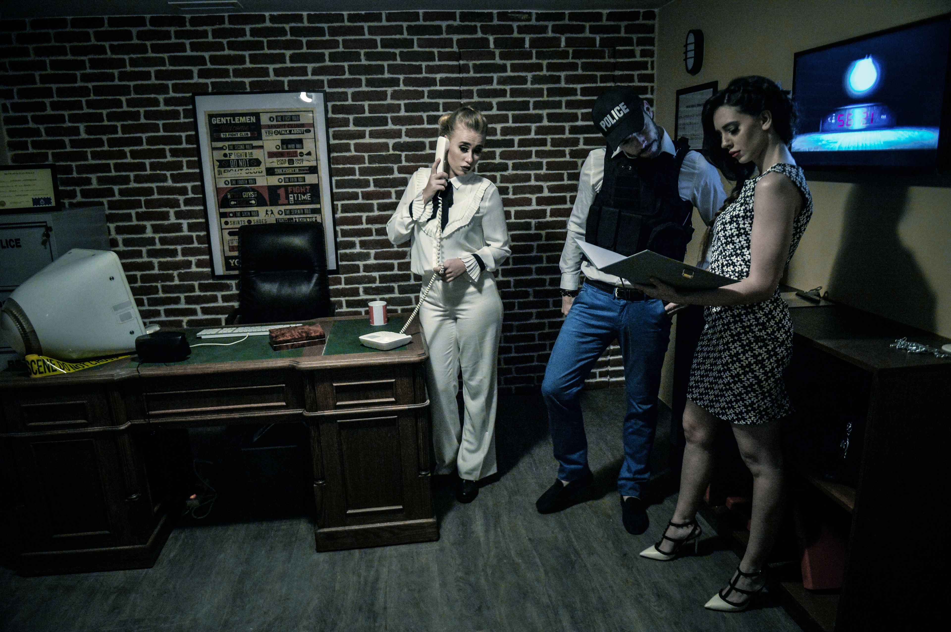A room with a brick wall, a desk with a telephone, a television, and a framed menu on the wall.