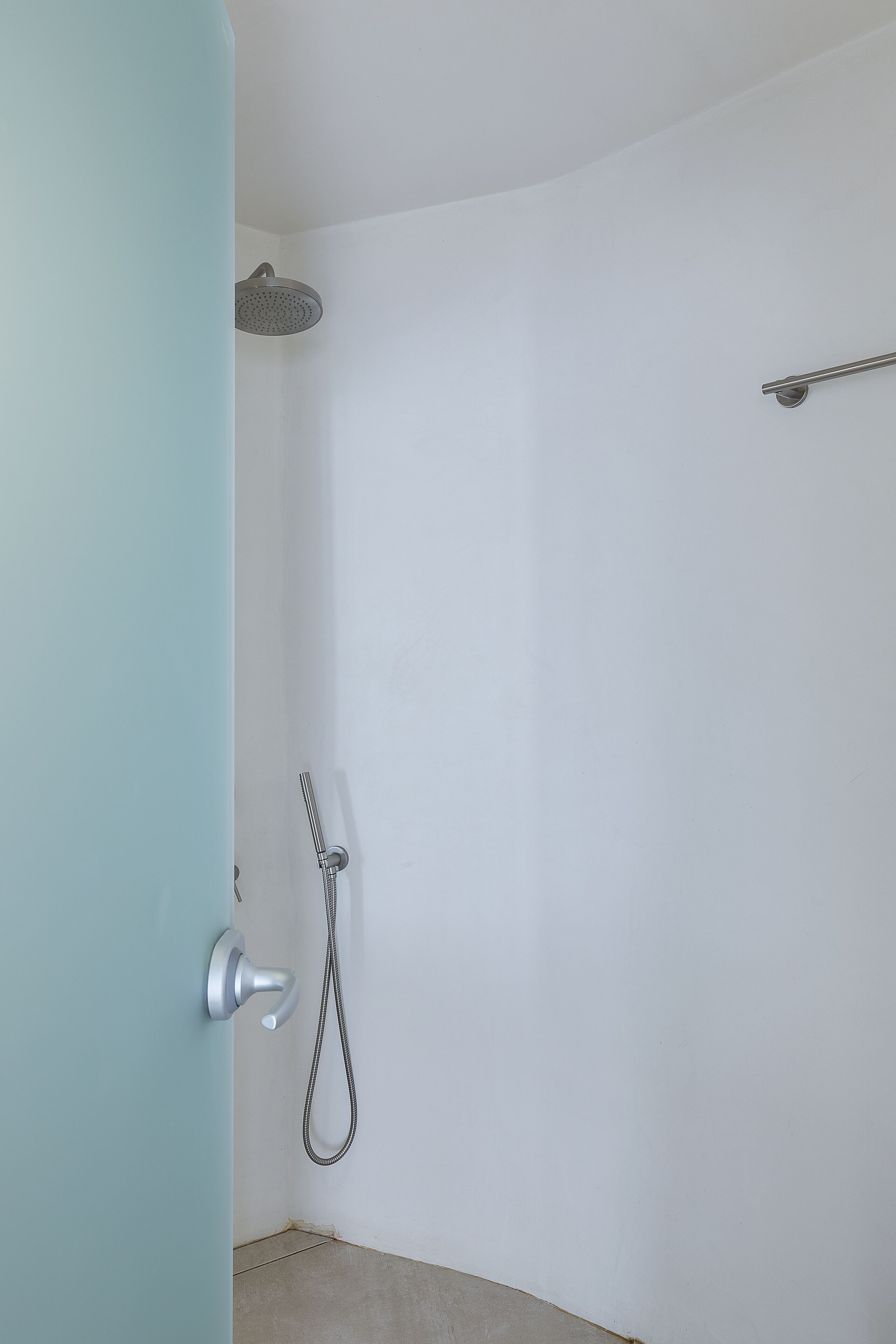 Un baño con ducha, toallero y puerta.