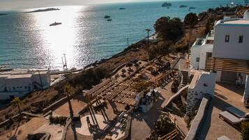 A coastal area with a pool, lounge chairs, and a view of the sea.