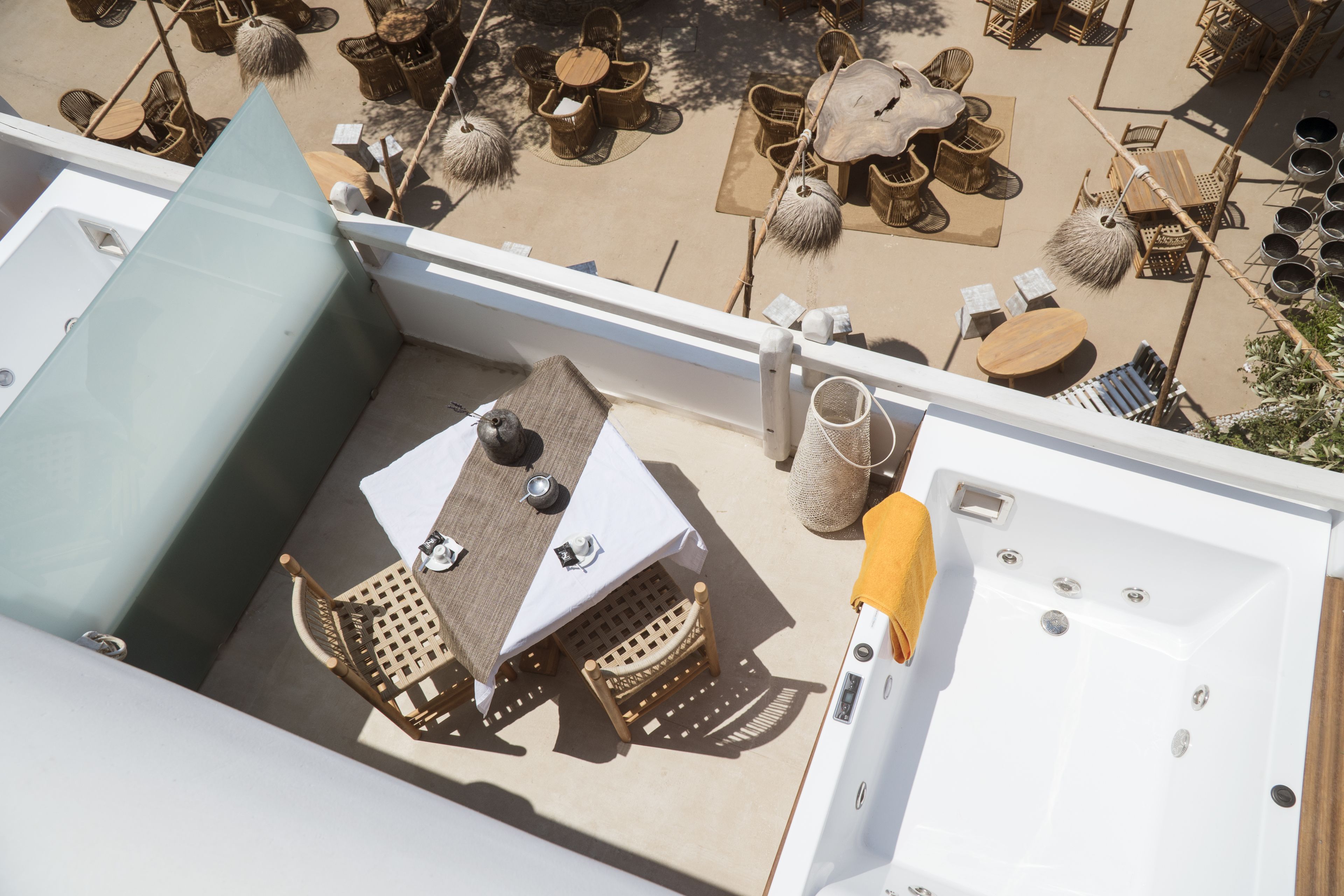 Um terraço no telhado com mesa, cadeiras, ofurô e mobiliário para áreas externas.