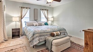 A bedroom with a bed, bedside lamps, a ceiling fan, and a rug. - 2 Mi to Lake McQueeny: Gem w/ Covered Patio (McQueeney)