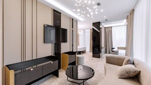 Une chambre d’hôtel moderne dotée d’une télévision à écran plat, d’un canapé, d’une table basse et d’un luminaire au plafond au design original.