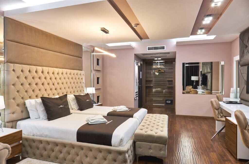Una habitación de hotel con una cama grande, un escritorio y un espejo.