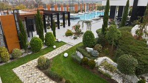 Un espace piscine extérieur moderne, doté d’une pergola, de sièges et offrant une vue sur le paysage.