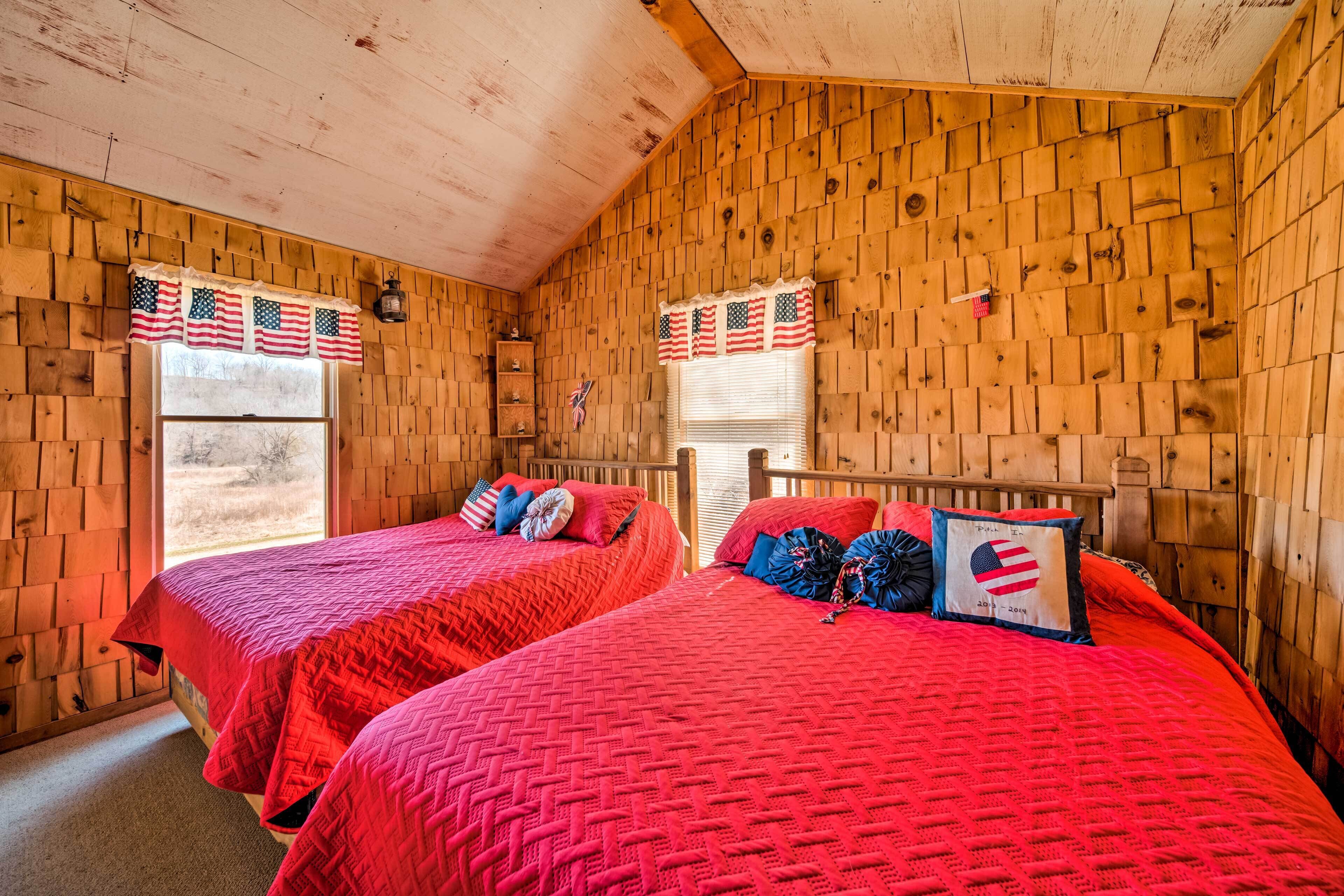 Une chambre avec deux lits, des murs en bois et des décorations aux couleurs du drapeau américain.