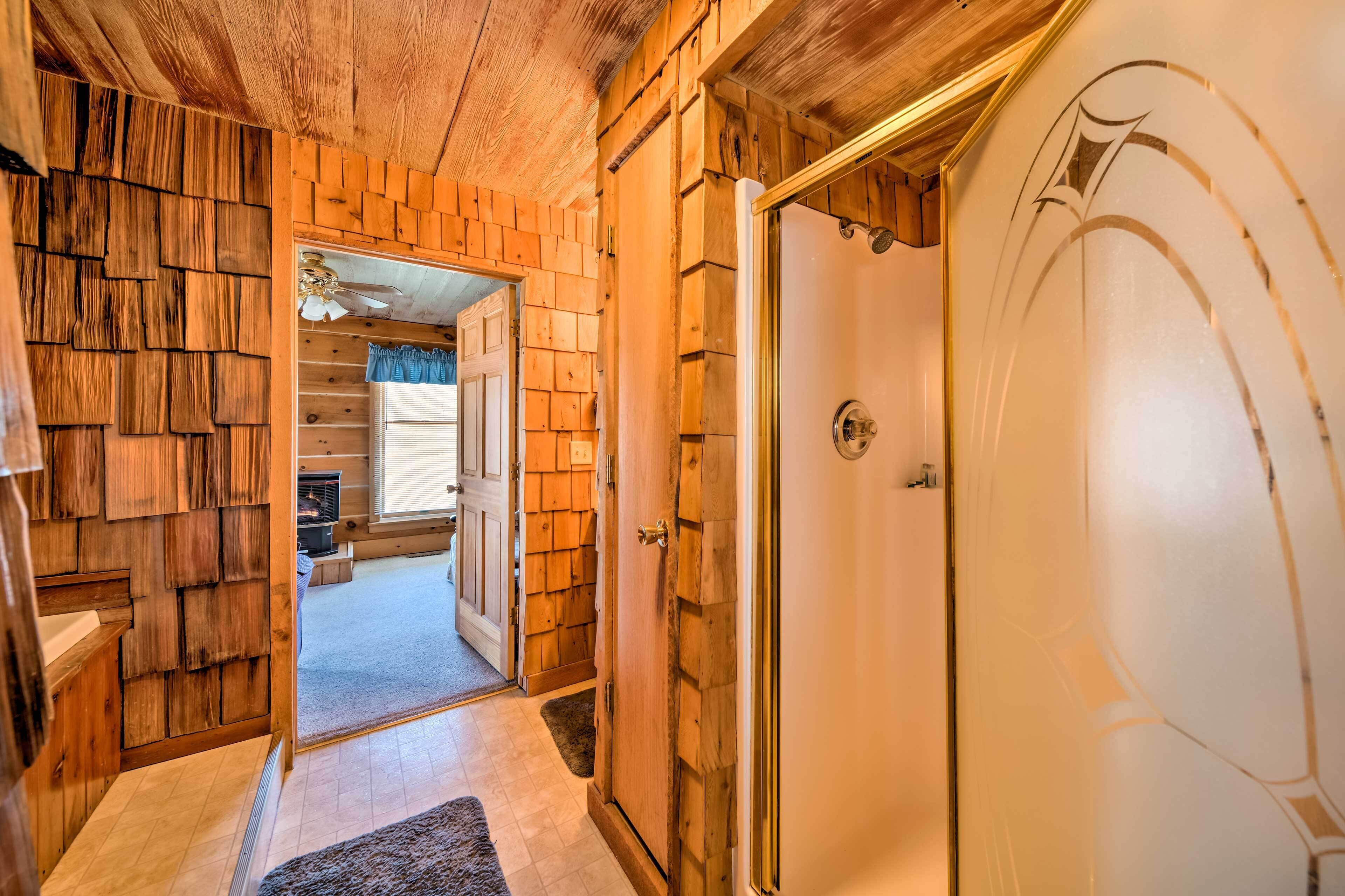 A wooden interior hallway leading to a room with a white door and a fireplace visible in the background.